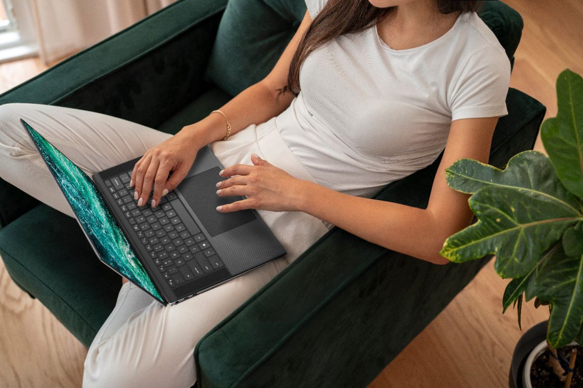 A user typing on the Dell XPS 15 in an armchair seen from above.