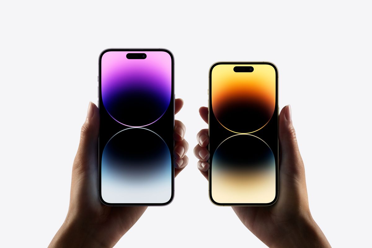 iPhone 14 Pro and iPhone 14 Pro Max are held side by side, their screens displaying colorful wallpaper.