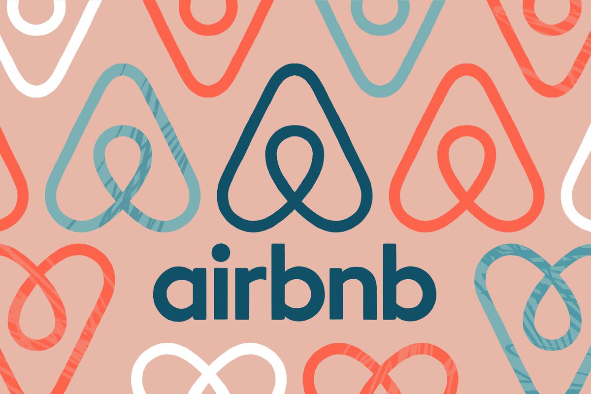 An illustration of Airbnbs logo in multiple colors on a red background.