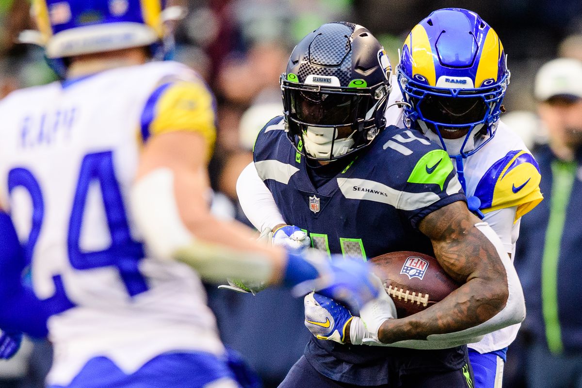 Jalen Ramsey #5 of the Los Angeles Rams tackles DK Metcalf #14 of the Seattle Seahawks during the fourth quarter of the game at Lumen Field on January 08, 2023 in Seattle, Washington.