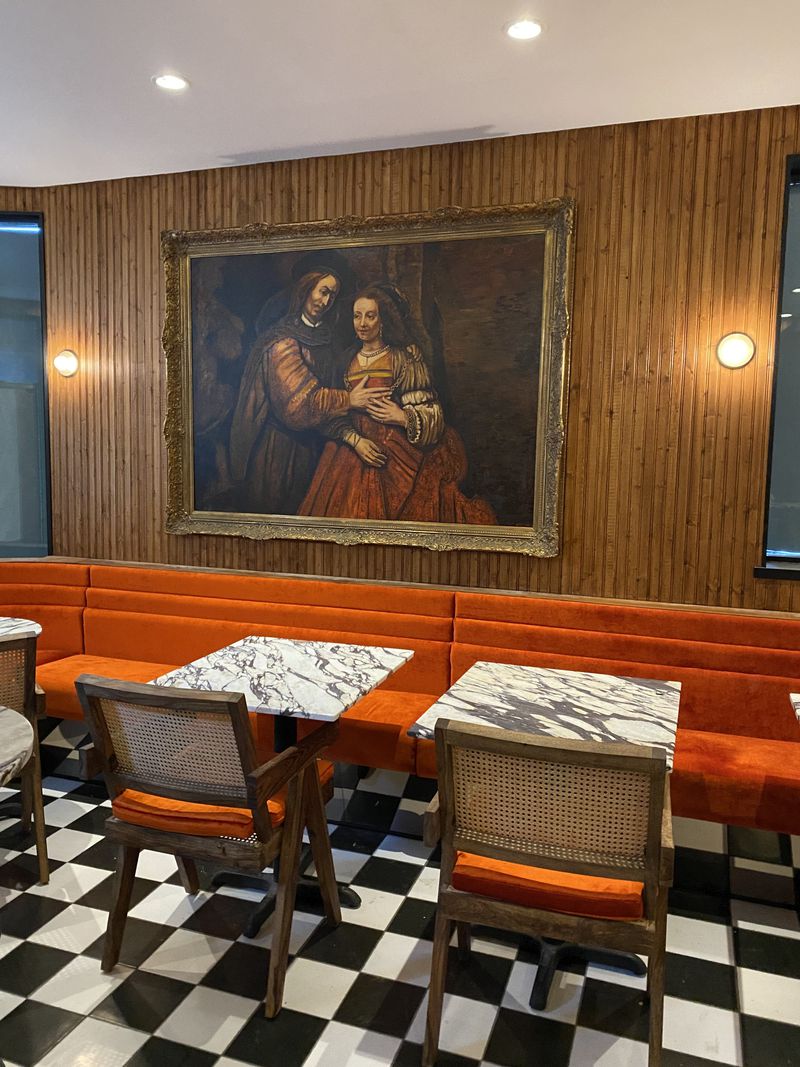 restaurant with wood walls, red seating and big painting