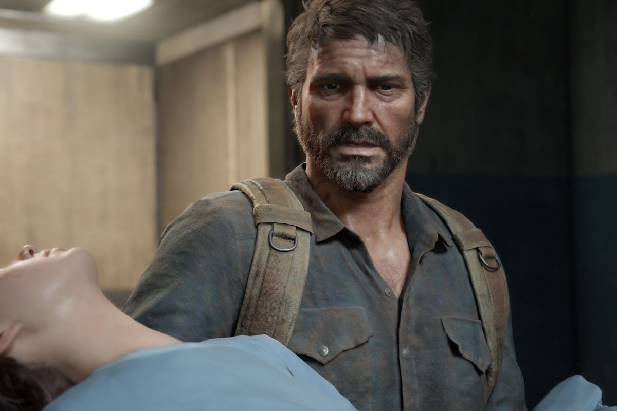 Joel holding Ellie in front of a wooden wall in The Last of Us Part 1