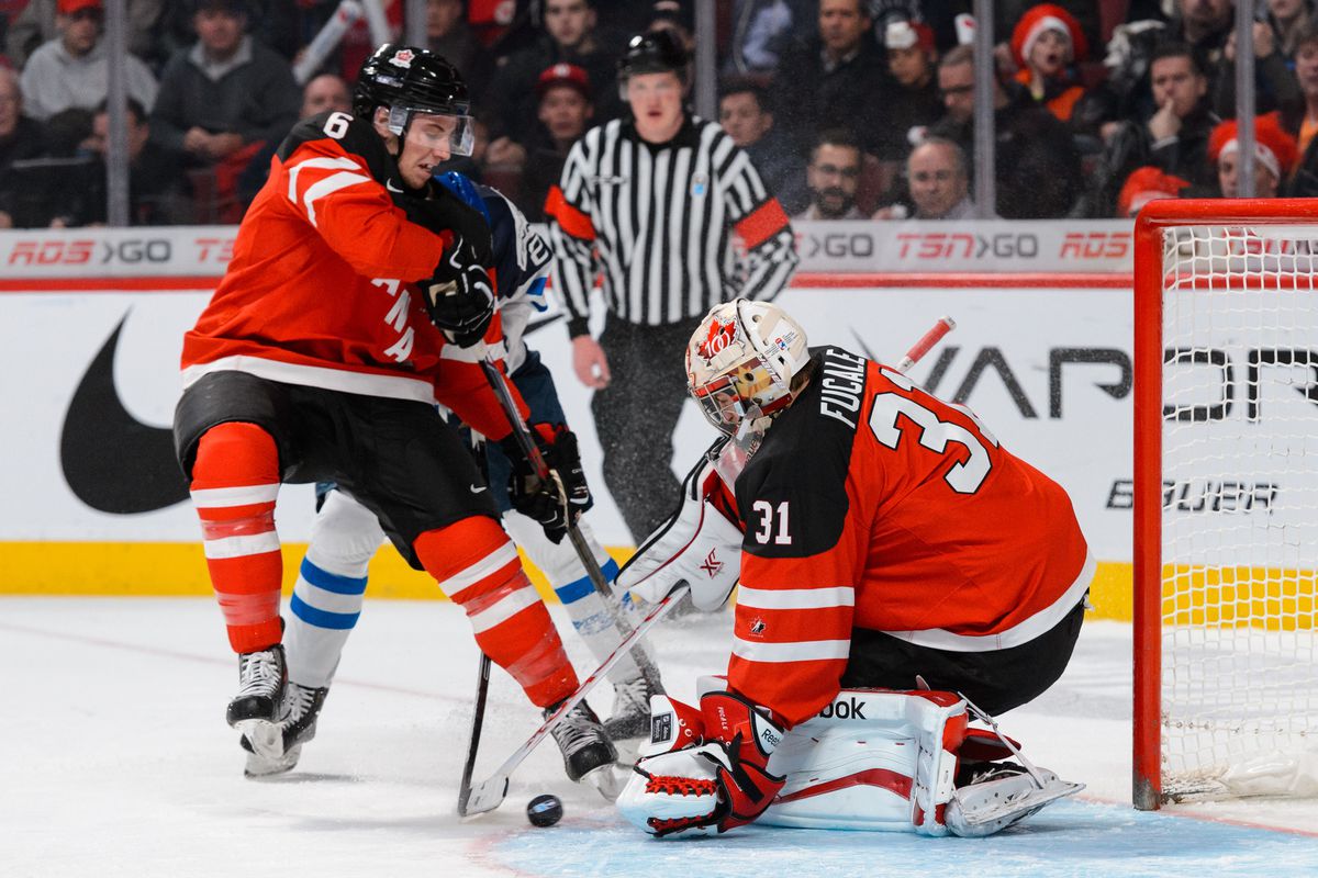 MONTREAL, QC - DECEMBER 29: Zachary Fucale #31 of Team Canada makes a save with teammate Shea Theodore #6 defending during the 2015 IIHF World Junior Hockey Championship