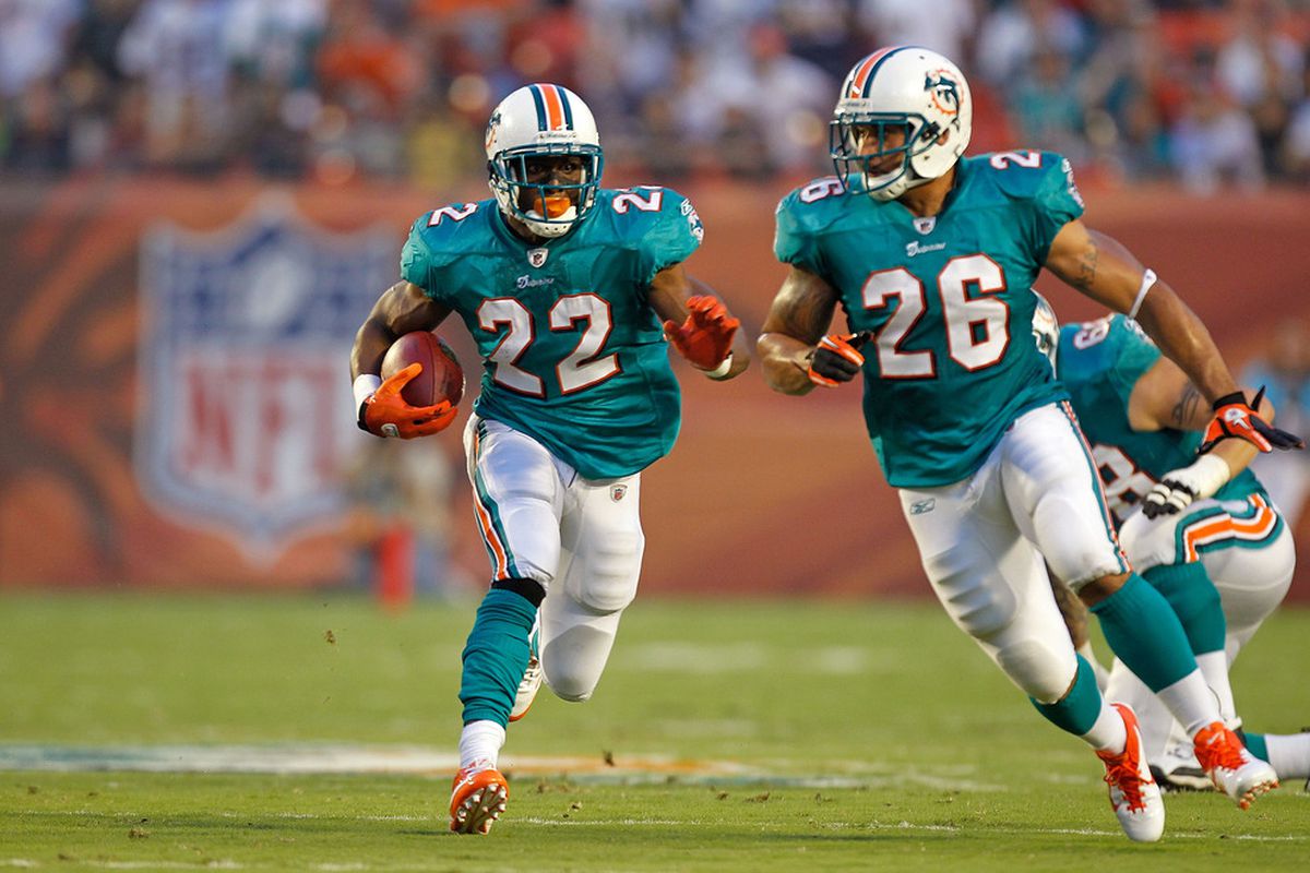 MIAMI GARDENS, FL - SEPTEMBER 12:  Reggie Bush #22 of the Miami Dolphins rushes during a game against the New England Patriots at Sun Life Stadium on September 12, 2011 in Miami Gardens, Florida.  (Photo by Mike Ehrmann/Getty Images)