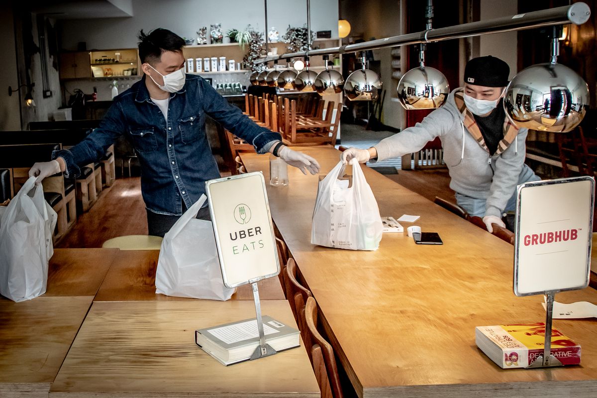Workers at Birds of a Feather organize bags of orders by delivery service