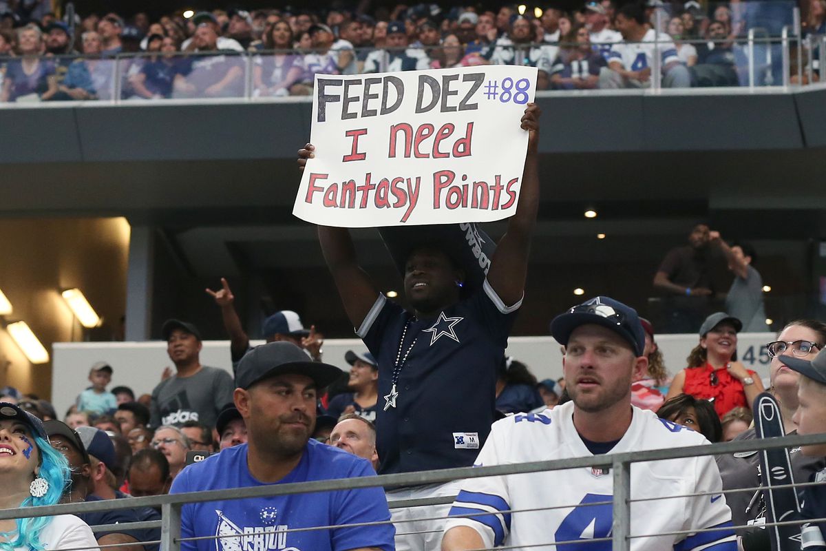 A Cowboys fan holding up a sign that says “Feed Dez! I need fantasy points!”
