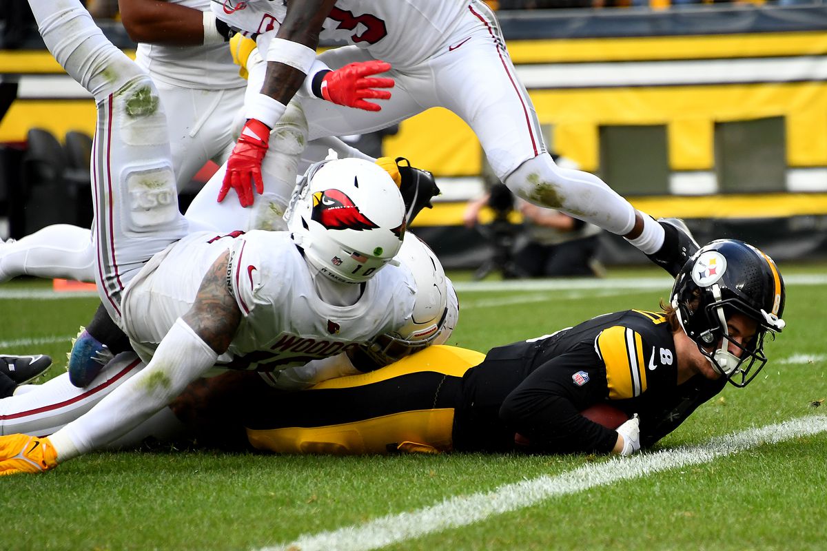 Josh Woods #10 of the Arizona Cardinals tackles Kenny Pickett #8 of the Pittsburgh Steelers during the second quarter at Acrisure Stadium on December 03, 2023 in Pittsburgh, Pennsylvania.