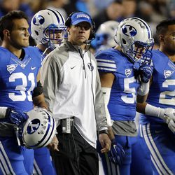 BYU head coach Bronco Mendenhall walks with his team during a timeout in the fourth quarter against Utah State in Provo, Friday, Oct. 3, 2014.