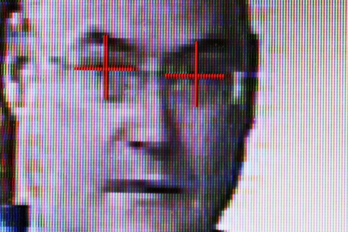 A pixelated photograph of a man’s face as it appears in facial recognition technology with crosses over the eyes.