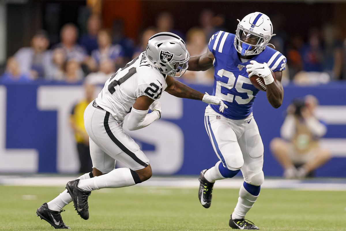 Marlon Mack of the Indianapolis Colts runs the ball as Gareon Conley of the Oakland Raiders defends at Lucas Oil Stadium on September 29, 2019 in Indianapolis, Indiana.