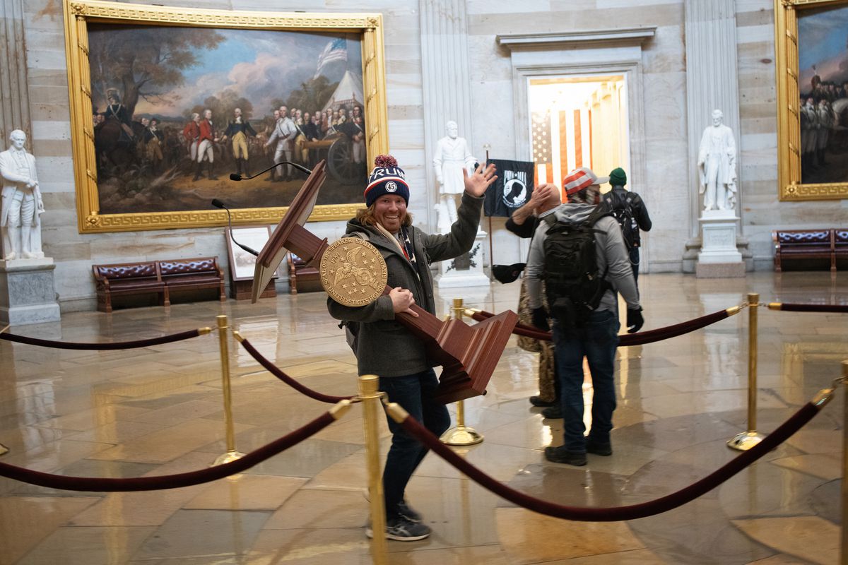 A pro-Trump protester carries the lectern of U.S. Speaker of the House Nancy Pelosi through the Rotunda of the U.S. Capitol Building after during a Jan. 6 riot. Authorities say it’s Florida man Adam Johnson.