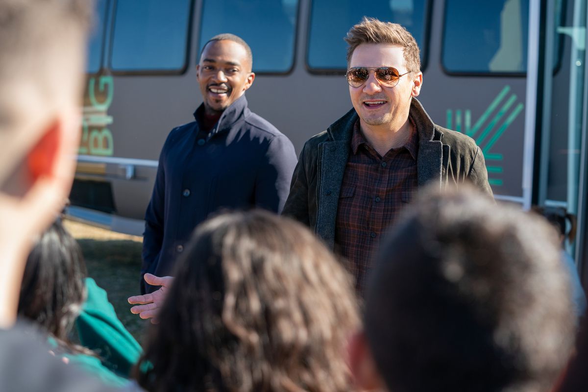 jeremy renner and anthony mackie exit a bus and greet a crowd