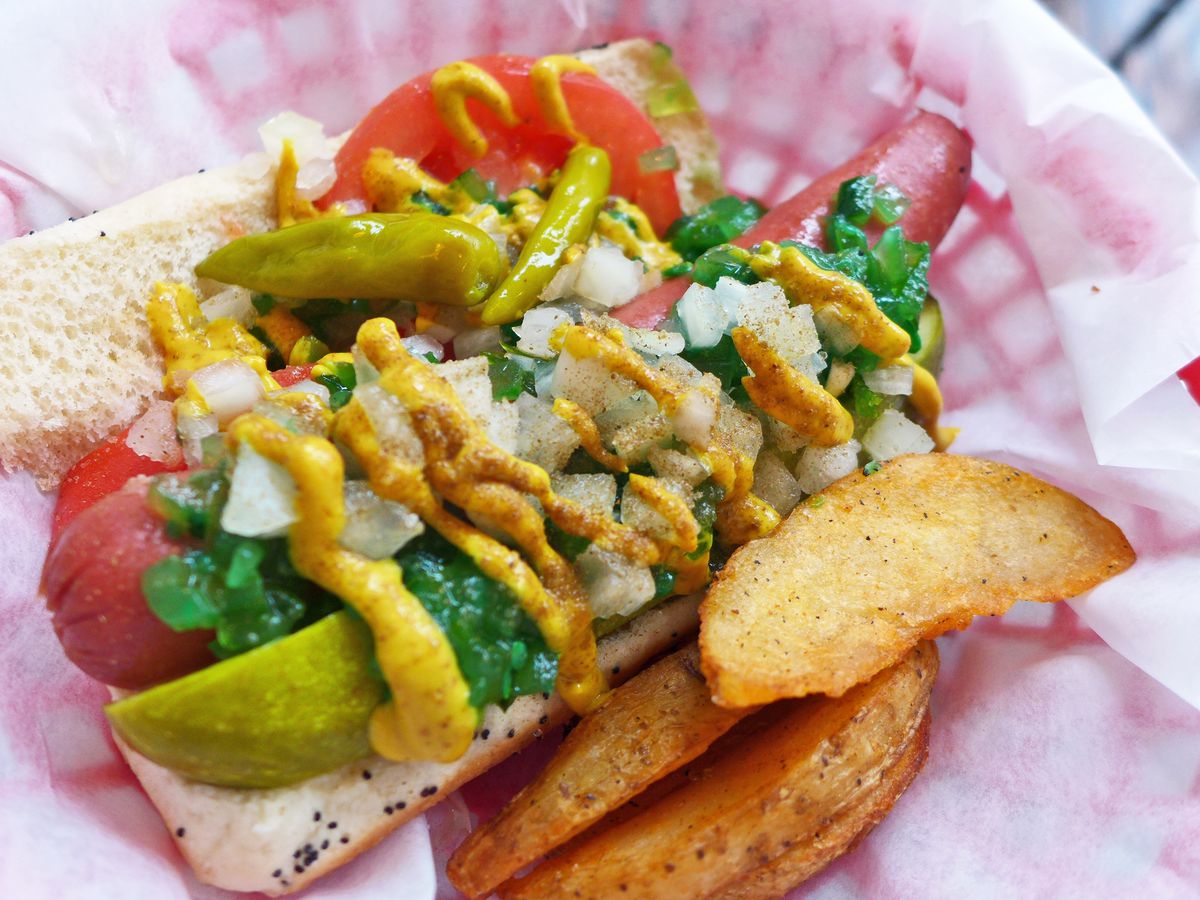 A hot dog in a bun almost eclipsed by its lush toppings.