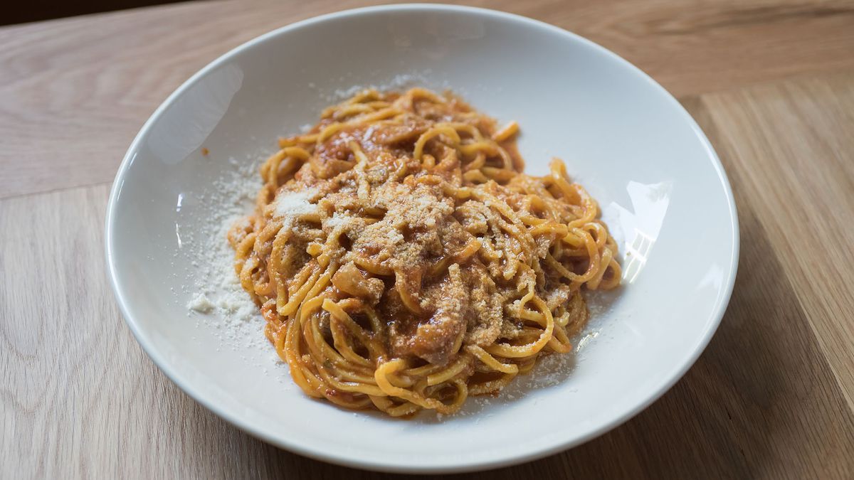 Plate of red sauce pasta on a white plate at Uovo. Tonnarelli amatriciana at Uovo.