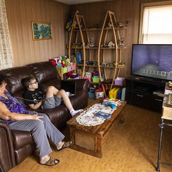 Danuta Kalinowska looks at her 12-year-old grandson Oliwier “Oli” Kluzik as he plays Minecraft at their Northwest Side home.