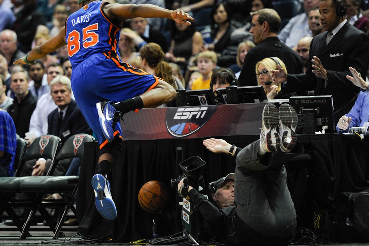 Apr 11, 2012; Milwaukee, WI, USA;  New York Knicks guard Baron Davis (85) sends a TV photographer sprawing while chasing for a loose ball against the Milwaukee Bucks in the 3rd period at the Bradley Center.  Mandatory Credit: Benny Sieu-US PRESSWIRE