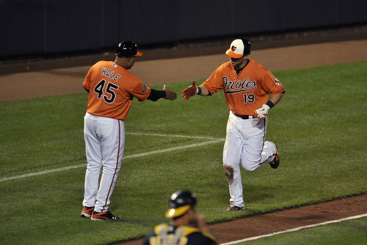 Baltimore Orioles first baseman Chris Davis (19) is congratulated by third base coach DeMarlo Hale (45) after hitting a solo home run in the seventh inning against the Oakland Athletics at Oriole Park at Camden Yards. 