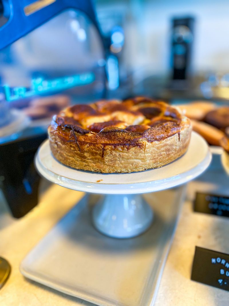 A tarte Normandie on white cake stand.
