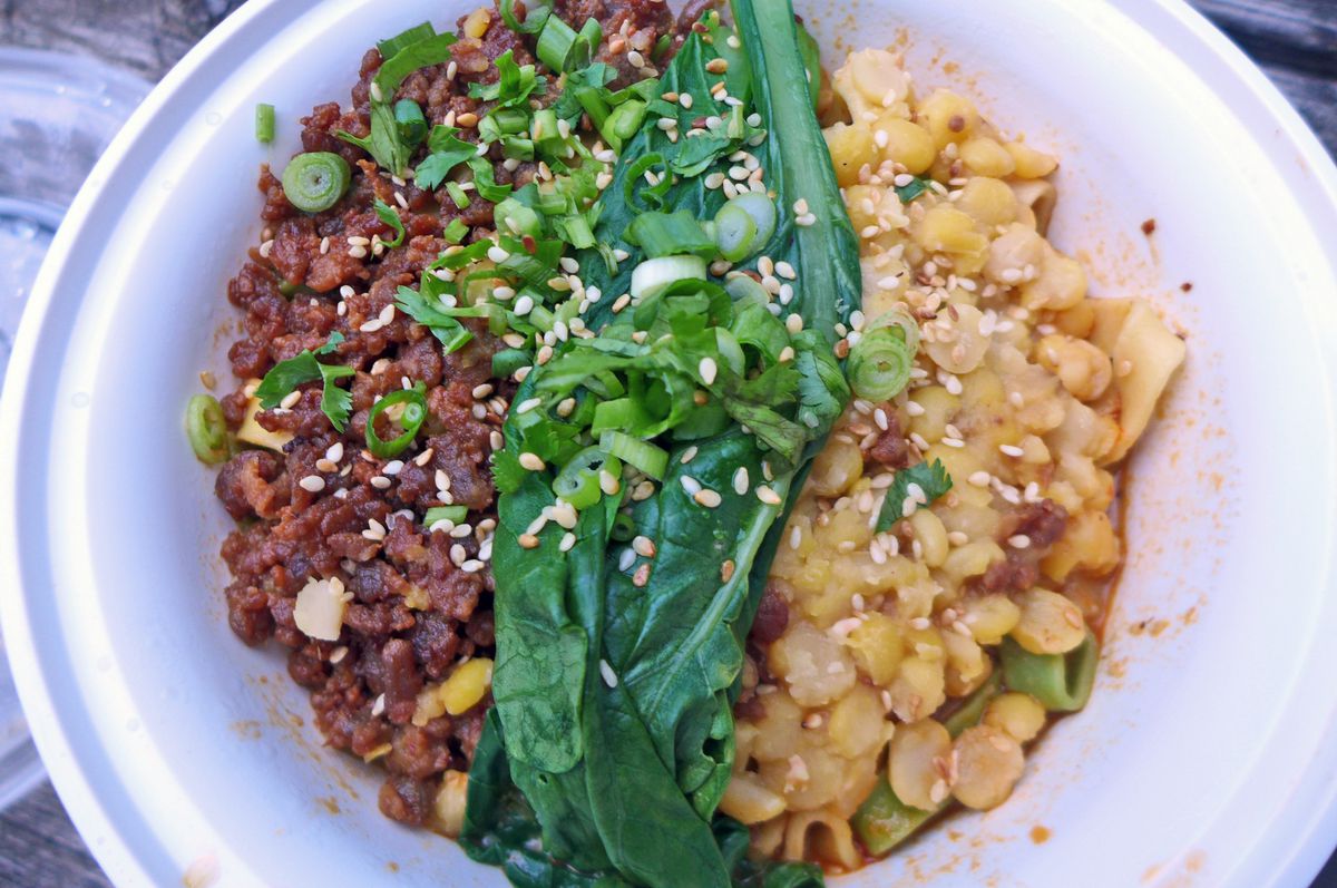 Bands of yellow split peas, ground pork, and spinach lie across the top of the dish.