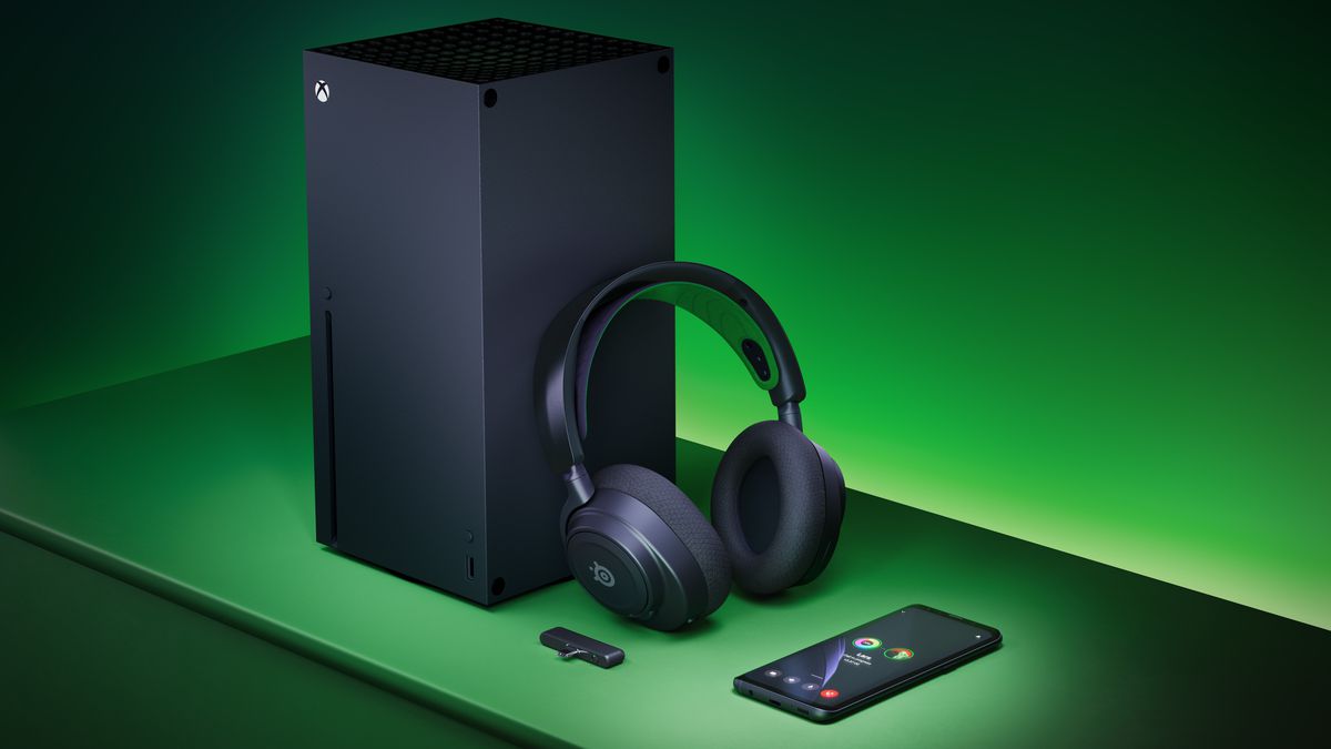 An image showing the SteelSeries Arctis Nova 7X Plus headset leaning on an Xbox Series X console. Near it is a USB-C dongle and a mobile phone. The room is green denoting its Xbox compatibility.