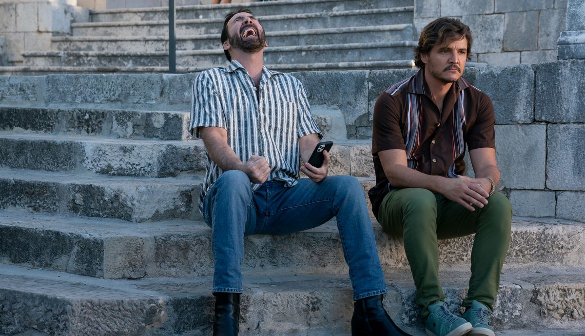 Nicolas Cage throws his head back and howls while Pedro Pascal looks glum in The Unbearable Weight of Massive Talent