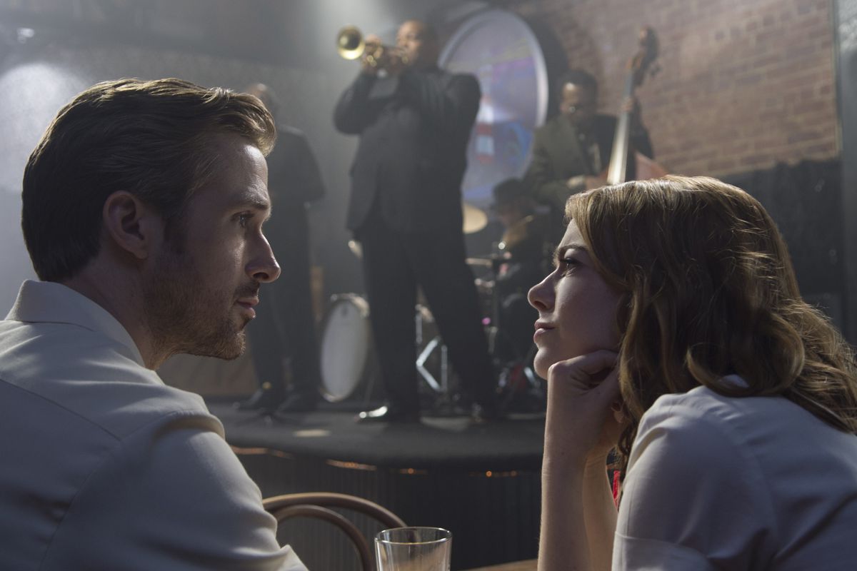 Emma Stone ponders the face of Ryan Gosling while a jazz band plays