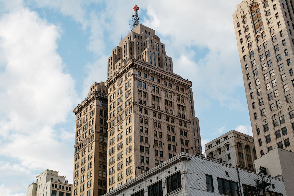 The exterior of the Penobscot building in Detroit. The facade is tan with a large red orb on the top.