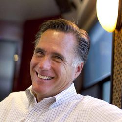 In this June 8, 2012, photo, Republican presidential candidate, former Massachusetts Gov. Mitt Romney smiles has he talks with his staff while riding on his bus after a campaign stop in Council Bluffs, Iowa. 