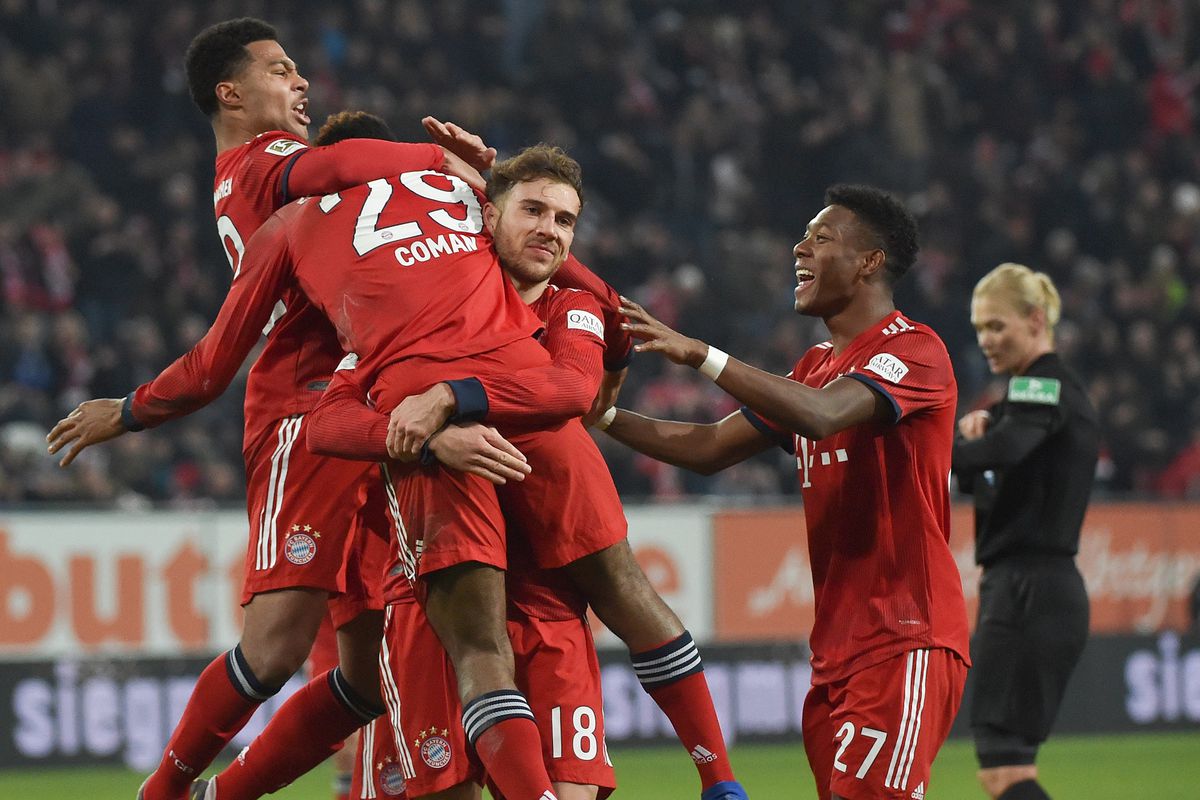 dpatop - 15 February 2019, Bavaria, Augsburg: Soccer: Bundesliga, FC Augsburg - Bayern Munich, 22nd matchday in the WWK-Arena. Munich player Serge Gnabry (l-r) cheers with 2-2 scorer Kingsley Coman and his teammates Leon Goretzka and David Alaba. Photo: Angelika Warmuth/dpa - IMPORTANT NOTE: In accordance with the requirements of the DFL Deutsche Fußball Liga or the DFB Deutscher Fußball-Bund, it is prohibited to use or have used photographs taken in the stadium and/or the match in the form of sequence images and/or video-like photo sequences.