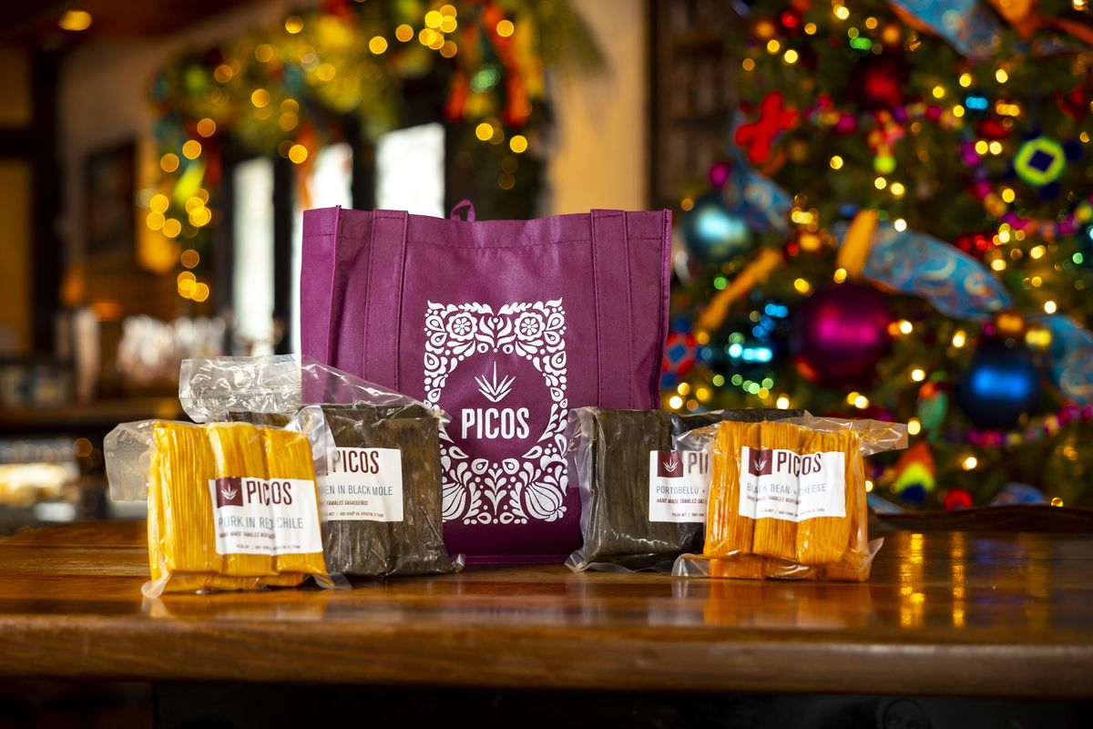 Packages of tamales in front of a Christmas tree.