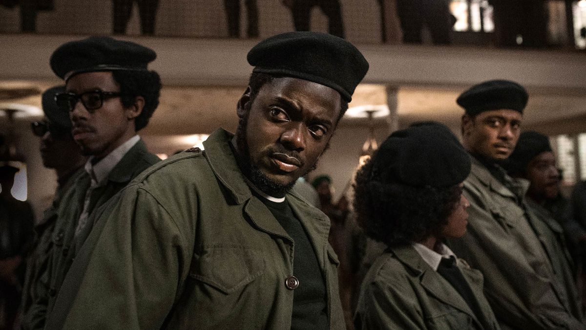 A group of Black Panthers stand looking warily, with Fred Hampton (played by Daniel Kaluuya) at the front of the group.