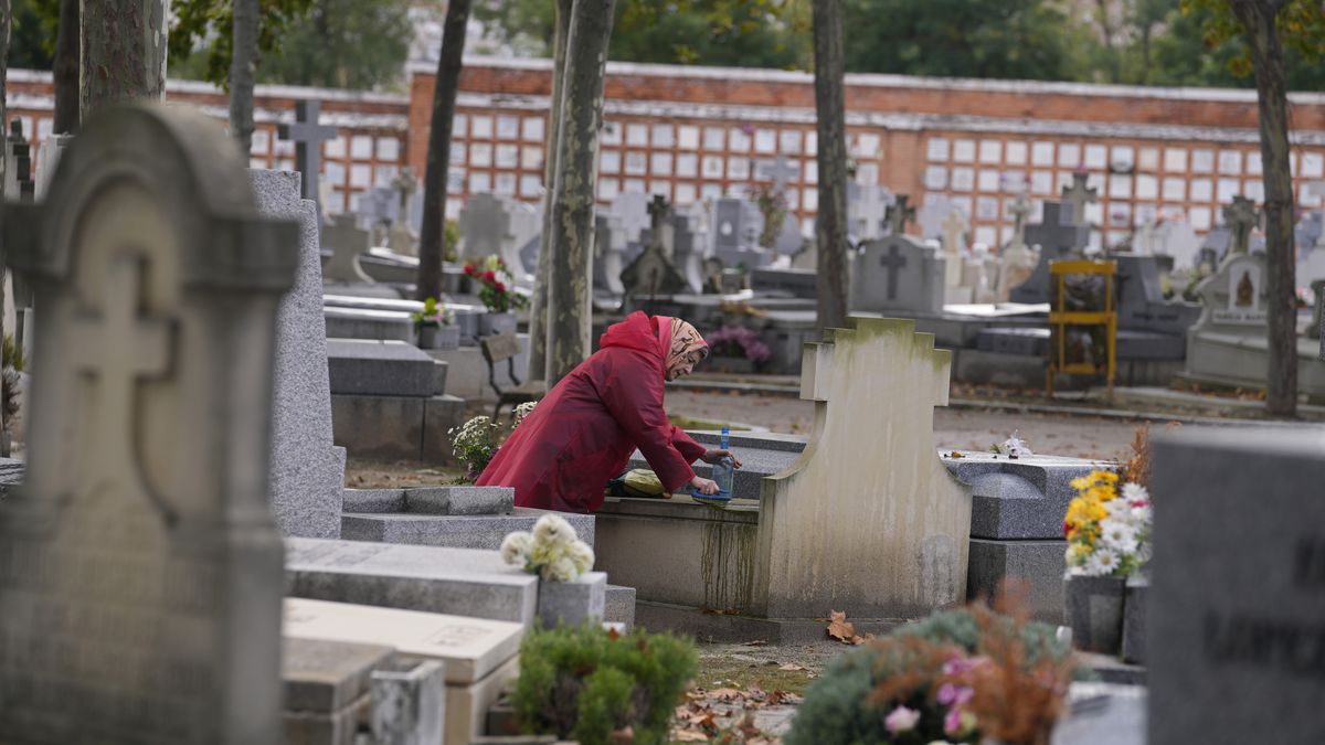 A woman cleans a relative’s tombstone in the Almudena cemetery a day before All Saints Day in Madrid, Spain.