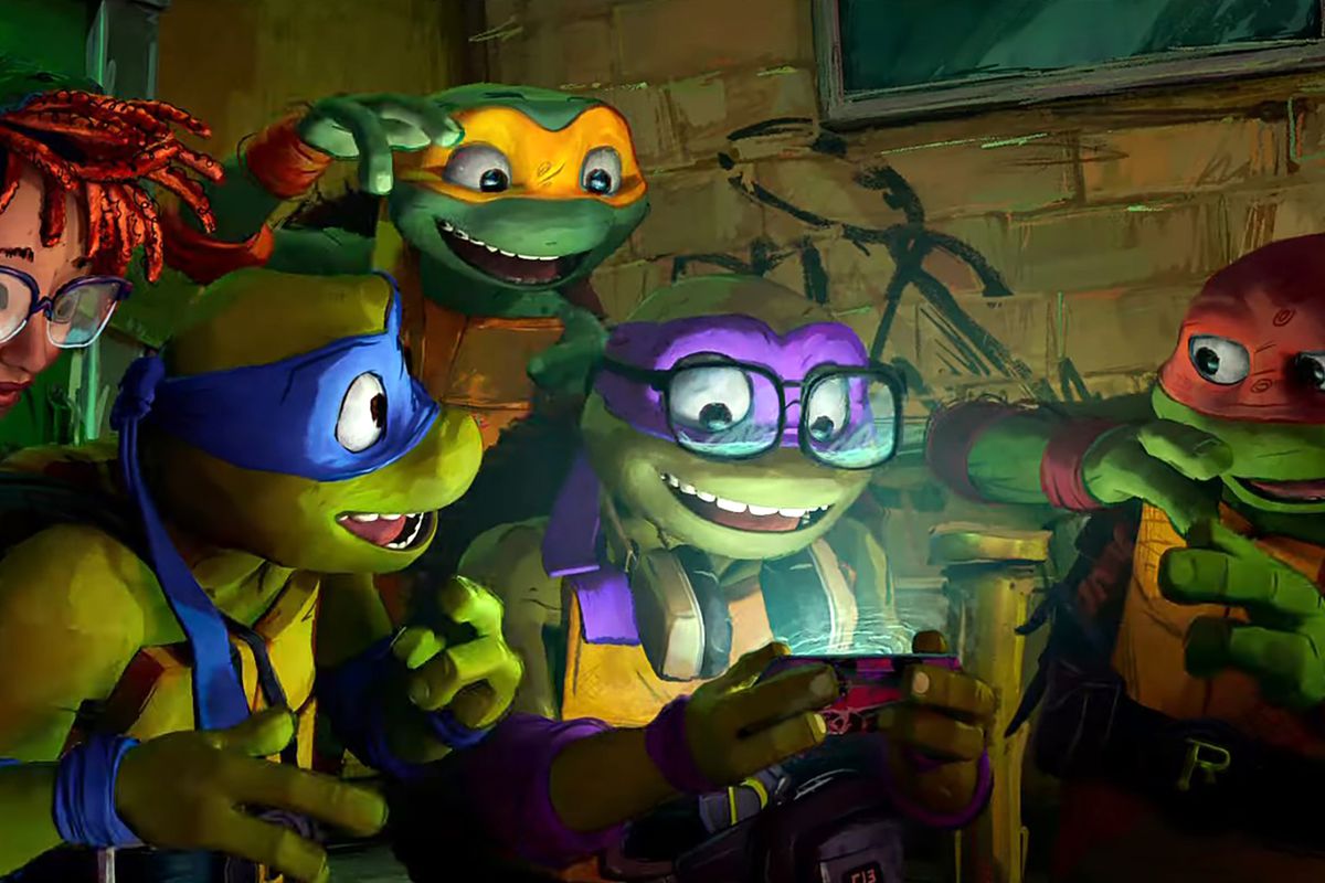 April O’Neil, Leonardo, Donatello, Raphael, and Michelangelo laugh while looking at a mobile phone in a still from Teenage Mutant Ninja Turtles: Mutant Mayhem