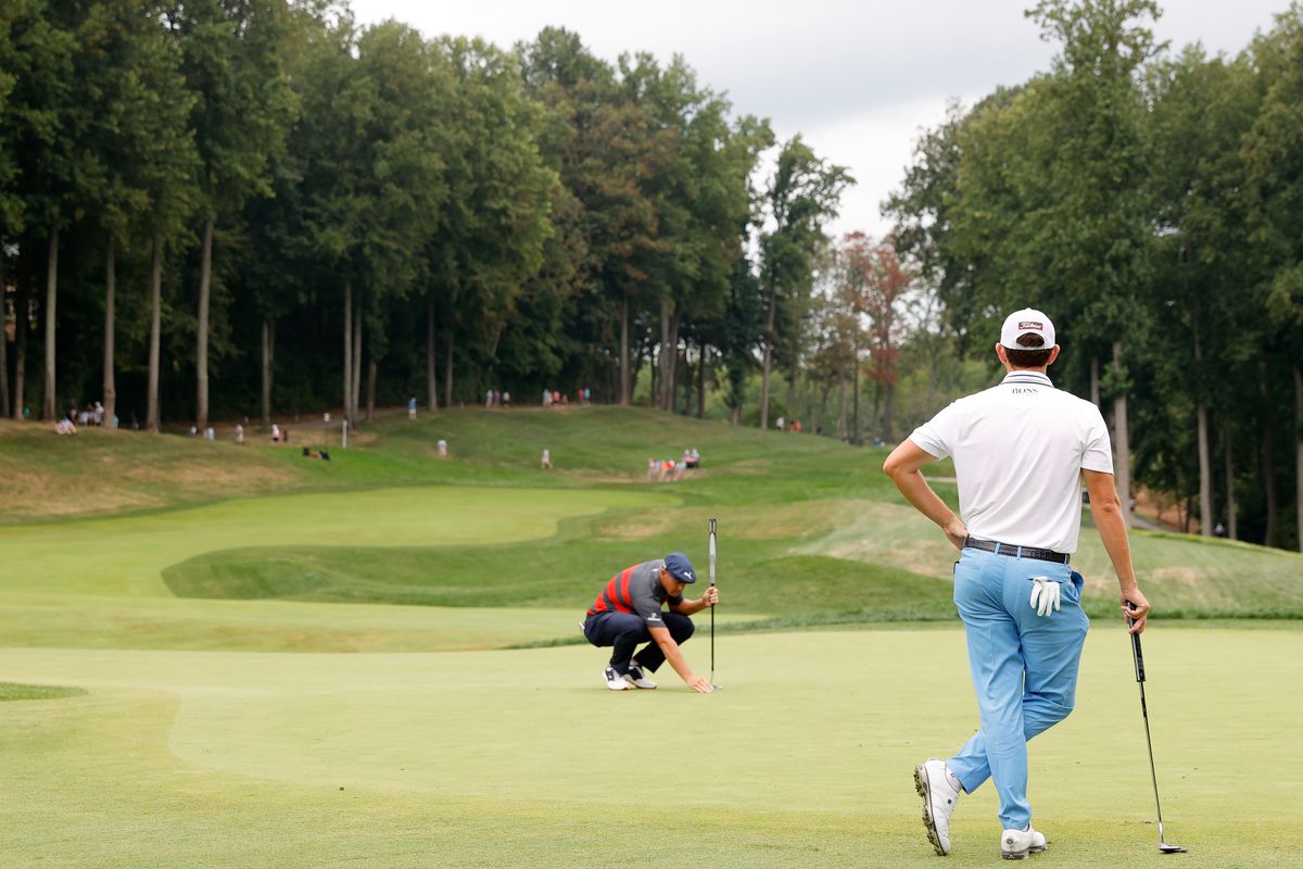 Bryson DeChambeau of the United States lines up a putt as Patrick Cantlay of the United States looks on during the final round of the BMW Championship at Caves Valley Golf Club on August 29, 2021 in Owings Mills, Maryland.