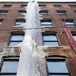 A cascade of ice adheres along the side of a brick building in downtown Boston, Friday, Feb. 20, 2015. Ice dams are a growing concern for homeowners in snowbound New England, where another storm is expected to bring snow, rain and freezing rain this weekend. The formations develop at the edge of a building's roof and prevent melting snow from draining, causing interior leaks and other damage. 