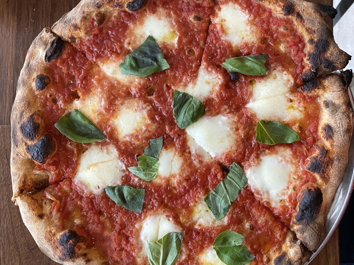 An overhead shot of the margherita pizza at Leo, showing off the pizza’s red tomatoes, green basil, and white mozzarella