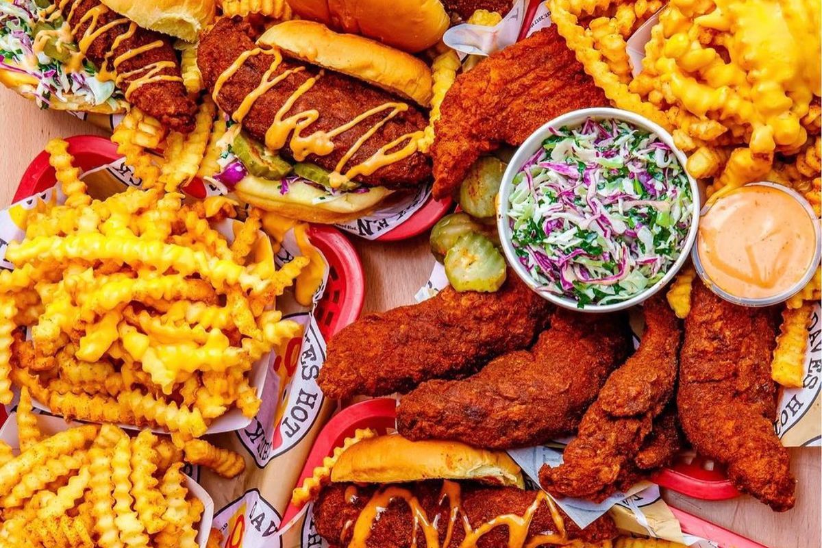 Hot and spicy fried chicken tenders and sandwiches piled up with baskets of crinkle fries at Dave’s Hot Chicken. 