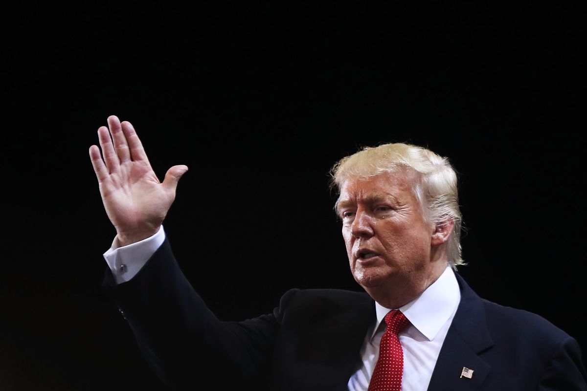 Donald Trump raises his right hand as he speaks in 2016.
