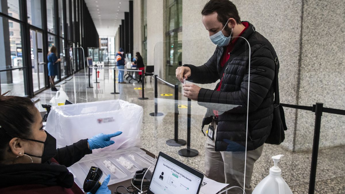 Attorney Patrick Berning-O’Neill, 32, of the Hyde Park neighborhood, submits a saliva sample to test for COVID-19 at a free community testing site in the lobby of the Dirksen Federal Courthouse, Wednesday morning, Jan. 12, 2022.