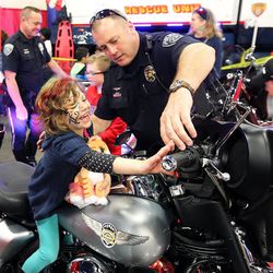 UPD officer Jason Appleman shows Anna Pentico the controls on his motor at the Safe Kid Fair Friday, Feb. 20, 2015, at the South Towne Expo in Sandy.