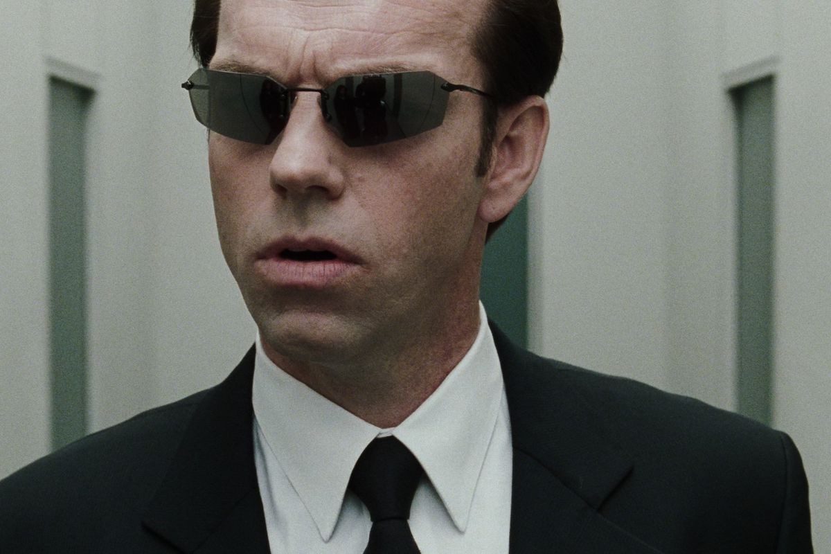 Agent Smith in The Matrix Revolutions walking down a white hall in his black shades
