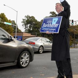 In this Nov. 4, 2014 file photo, Arkansas Democratic Lt. Governor John Burkhalter waves to commuters at a campaign stop in Little Rock, Ark. The Arkansas construction company owner put up $2 million of his own money seeking the part-time job of lieutenant governor.