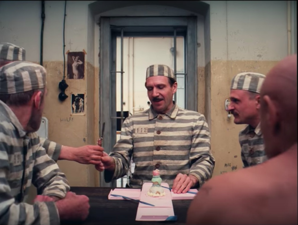 Monsieur Gustave serves a Mendl’s pastry to his imprisoned friends
