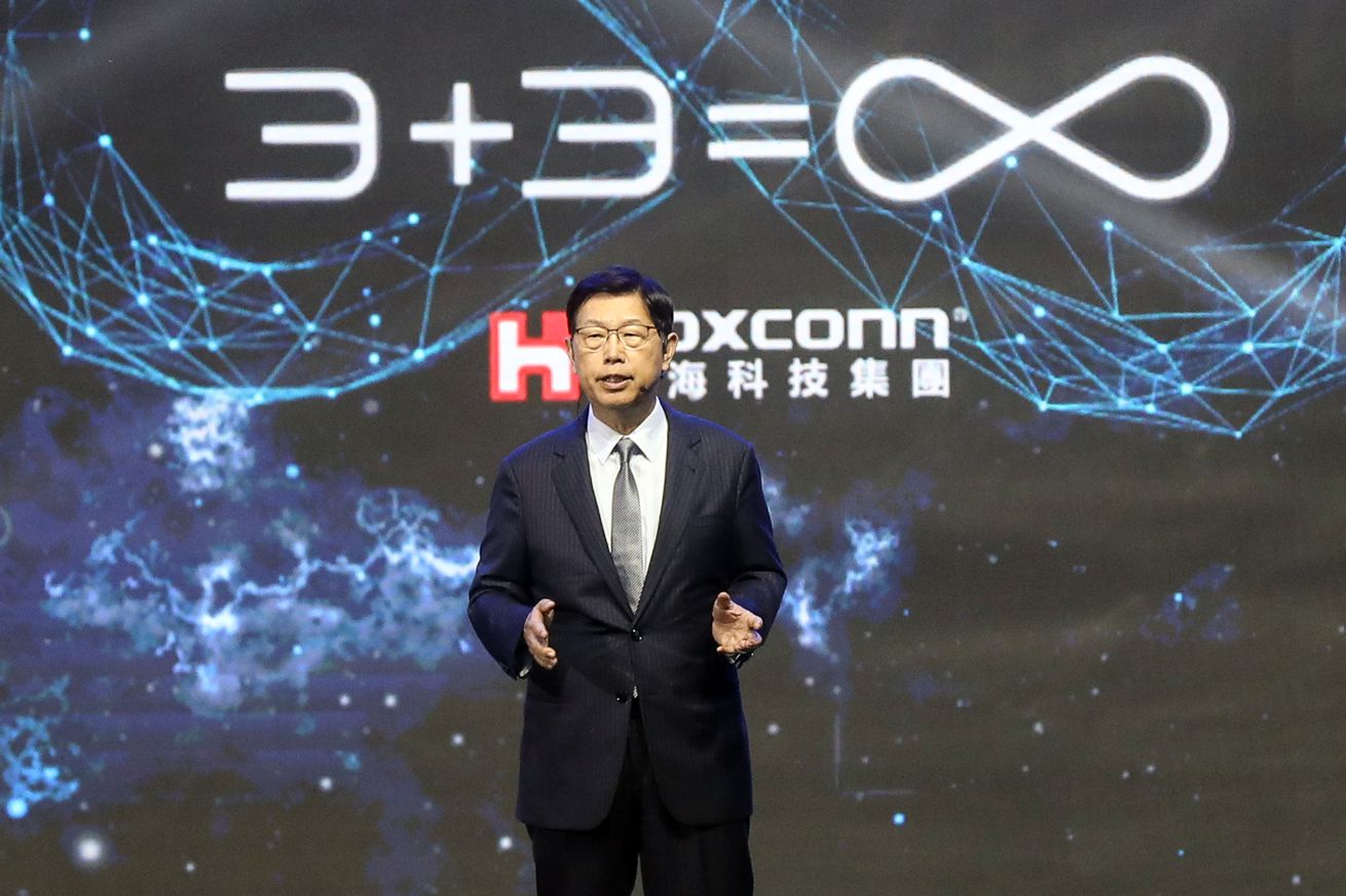 Foxconn President Liu Young-way in front of a slide that says “3+3=∞”