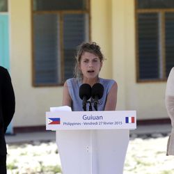 French actress Melanie Laurent, center, reads her statement on climate change during the visit by President Francois Hollande, left, of France to the Guiuan East Central School at the typhoon-ravaged Guiuan township, Eastern Samar province in central Philippines Friday, Feb. 27, 2015. Hollande's two-day state visit focuses on climate change. At right is Guiuan Mayor Christopher Sheen Gonzales. 