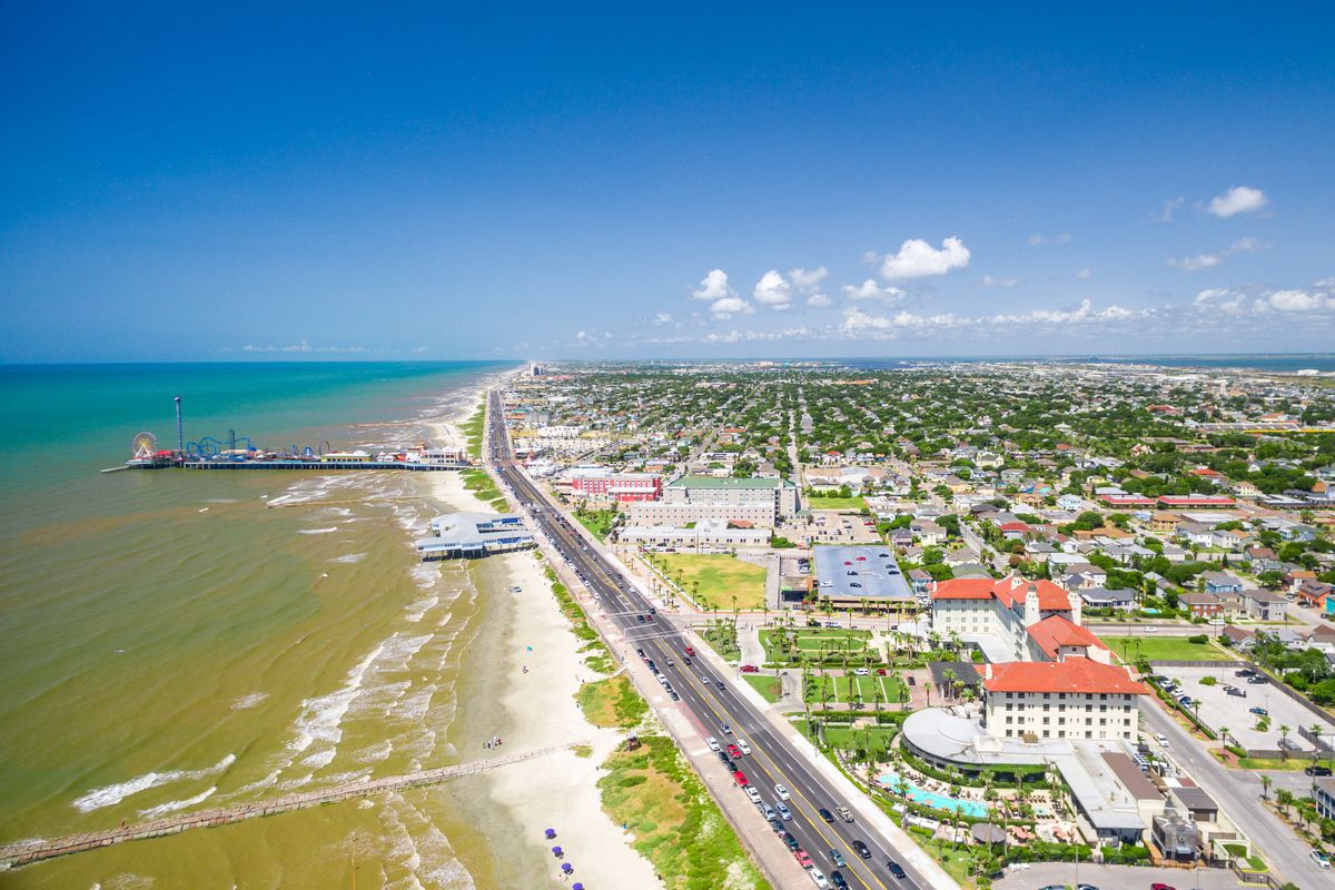 An aerial view of the Galveston coast with the Pleasure Pier in the far background.