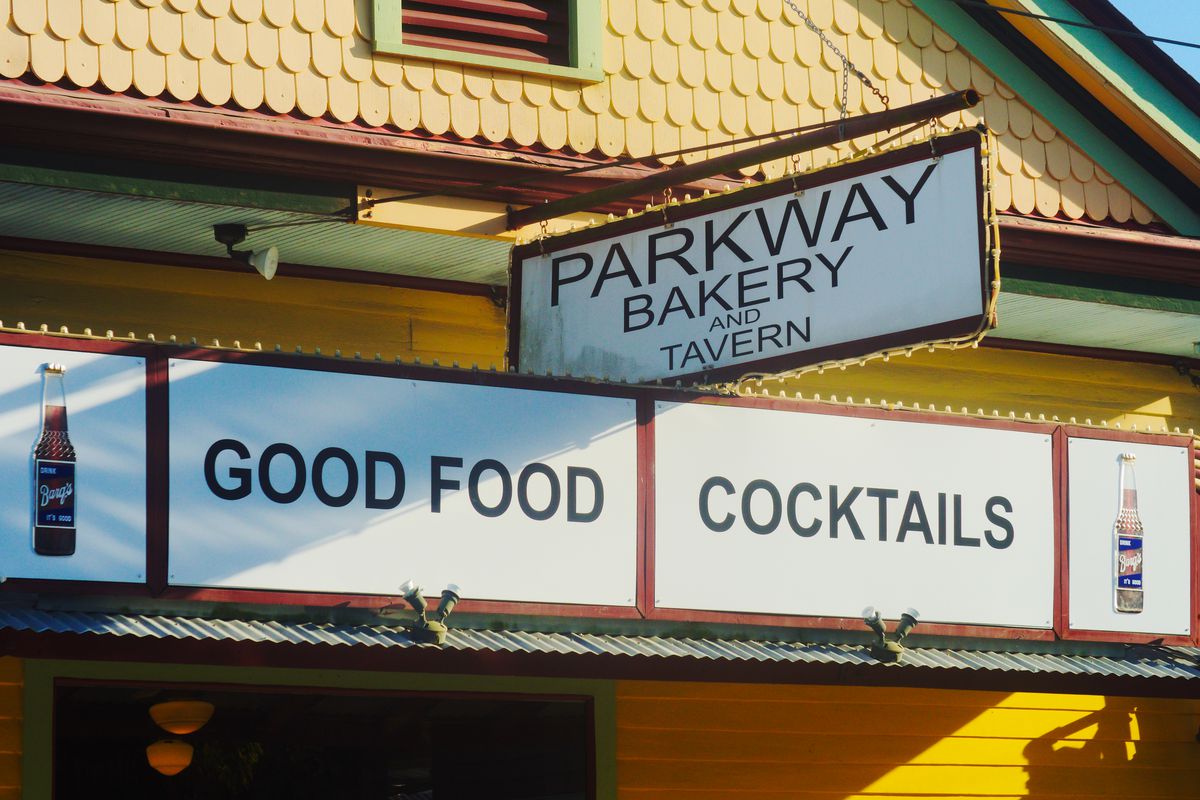 An old-school Parkway Bakery and Tavern sign hangs on a corner building.