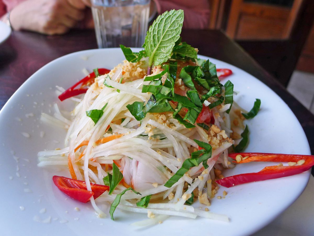 Shredded green papaya heaped in a salad with slender red chiles and mint leaves.