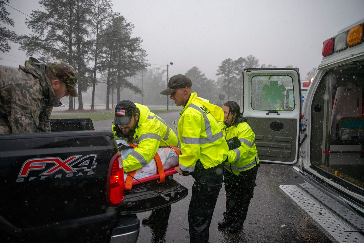 Ben Husser (L) of the Cajun Navy, helps emergency workers transfer a patient to their ambulance after the evacuation of a nursing home due to rising flood waters in Lumberton, North Carolina, on September 15, 2018 in the wake of Hurricane Florence.