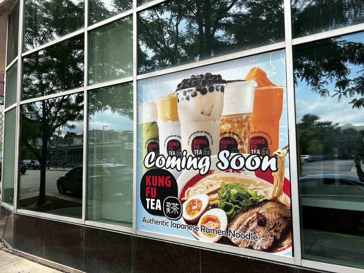 A “coming soon” sign outside a building with bubble teas and a bowl of ramen.